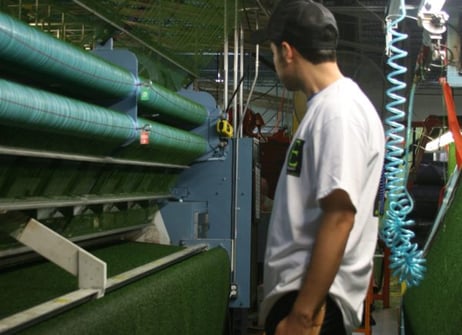 Precision tufting and polyurethane backing system for premium synthetic grass products